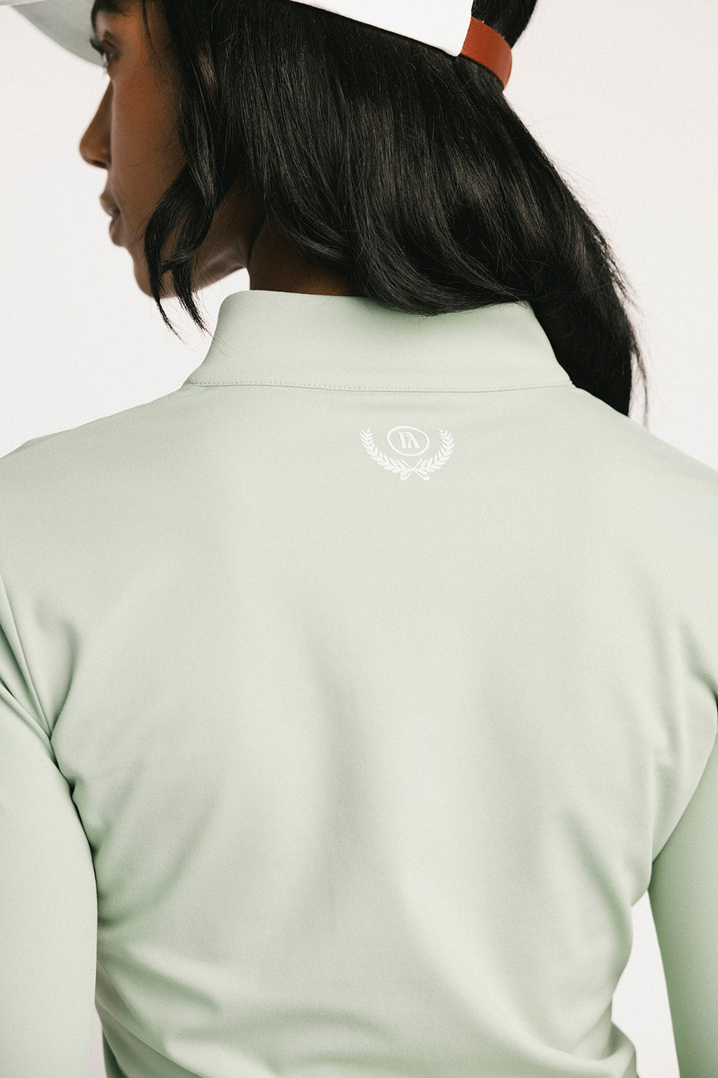 Light green long-sleeve shirt with a logo on the chest against a white background